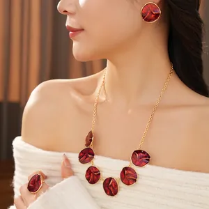 Vintage gold jewelry set with red round drip oil charms worn by a female model
