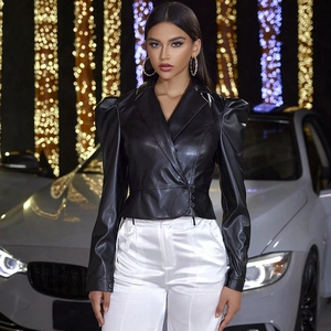 Detail of puff sleeves and button fasteners on a black faux leather cropped jacket