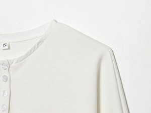 Detailed macro view of white Henley collar with three buttons on knitted cotton dress