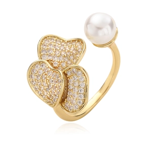 Gold-plated ring with shimmering zircon heart elements and a white pearl on white background