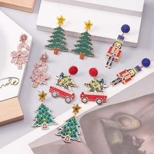 Christmas themed alloy earrings set with colorful rhinestones and beads on white background