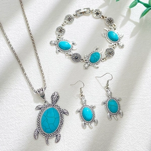 Bohemian turquoise turtle necklace, bracelet and earrings jewelry set on white fabric