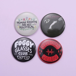 Set of four unique tinplate button pins with creative quotes and English slogans