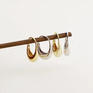 Minimalist 925 silver hoop earrings in gold and silver finish hanging on wood