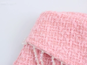 Detail aus rosa Tweed-Stoff mit transparenten Kristallperlen-Fransen am Hosensaum