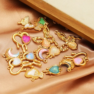 Golden heart, moon, and butterfly pendants with colorful stones on bronze silk fabric