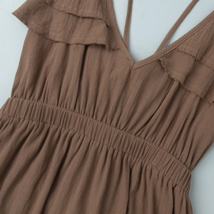 Détail d'une robe marron en coton et lin avec décolleté en V à volants et taille élastique