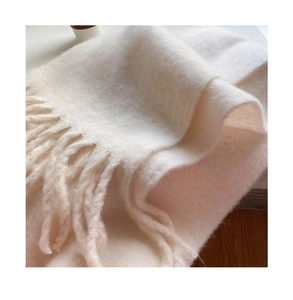 Close-up of soft beige plush scarf featuring thick fluffy texture and tassel edge detail