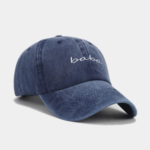 Detail der gewaschenen blauen Denim-Basecap mit weißer baba-Stickerei und Ziernähten am Schirm