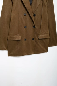 Detailed view of brown double-breasted suede jacket with lapels and pocket details