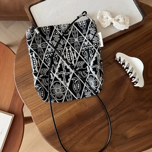 Detail of vintage canvas crossbody bag with intricate black and white ethnic embroidery