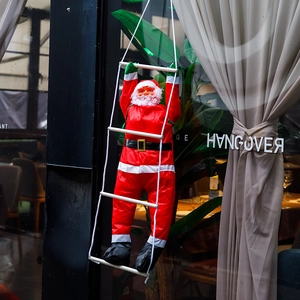 Dettaglio di Babbo Natale che sale una scala di corda a quattro pioli per decorazioni