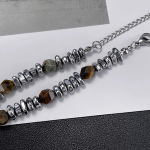 Detail of stainless steel bracelet with faceted natural yellow tiger eye beads and lobster clasp