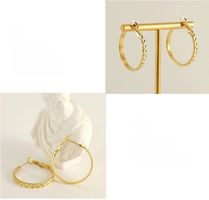 Detailed macro view of 18k gold plated stainless steel earrings with textured rhombus pattern
