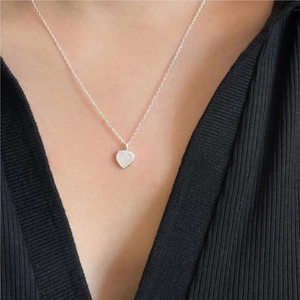 Minimalist 925 sterling silver heart necklace with white crystal on a female model