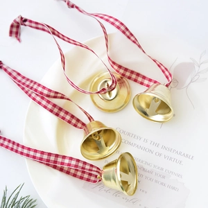Golden Christmas bells with red and white checkered ribbon for festive tree decoration