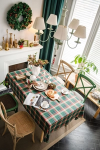 Close-up of green and red plaid tablecloth with rustic wooden chair for Christmas decor