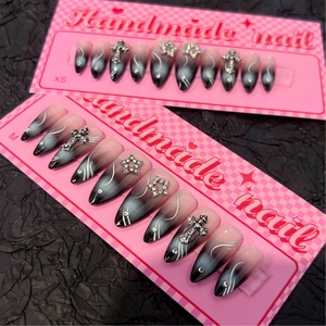 Faux ongles amande faits main dégradé noir et rose avec croix argentées et strass