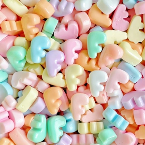 Macro view of macaron colored resin F-letter beads for DIY phone cases and hair accessories