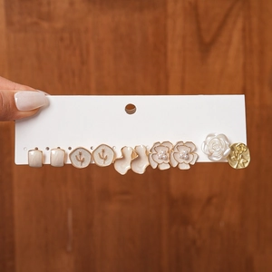 Close-up of a 6-pair vintage earring set featuring resin flowers, pearls and golden studs