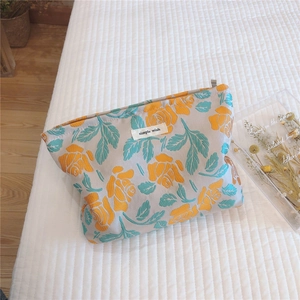 Macro detail of retro floral jacquard pouch with rose embroidery and simple wish label