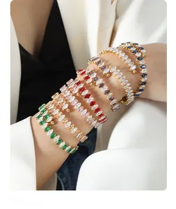 Close-up of elegant gold bracelets set with colorful marquise-cut zircon stones