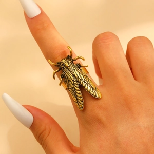Detailed close-up of a vintage-style golden cicada ring showing 3D wing textures