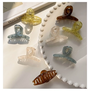 Detailed view of translucent 4.5cm hair claw clips in various colors on a white tray