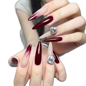 Long stiletto press-on nails in burgundy flame design with luxury rhinestones