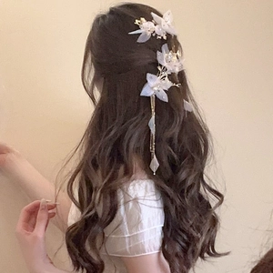Détail de barrettes à fleurs faites main avec pétales en tissu et pompons métalliques