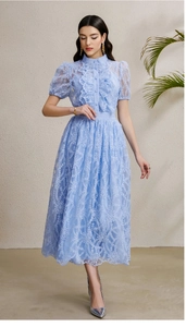 Close-up of light blue floral lace fabric with ruffled details and puff sleeves