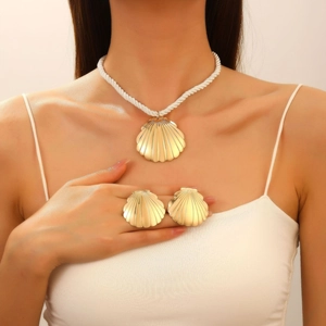 Golden seashell jewelry set with necklace and earrings on white braided rope