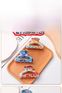 Set di tre mollette per capelli floreali a semicerchio nei colori arancio, blu e rosa