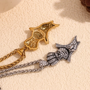 Macro view of gold fish pendant and silver rhinestone fish pendant on woven chain necklaces