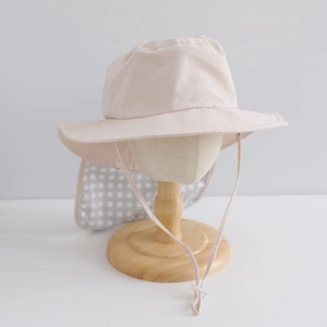 Close-up of kids sun hat featuring a pink brim and checkered neck protection flap
