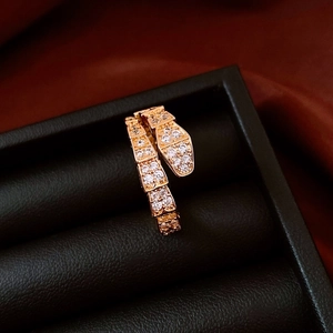 Détail macro de bague serpent en or rose sertie de zircons sur écrin en cuir noir