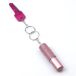 Pink rhinestone perfume keychain with metal key charm on a clean white background