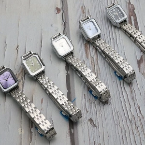 Collection of five elegant square quartz watches with colorful dials on wooden background
