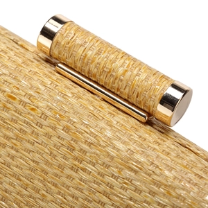 Macro shot of golden woven texture and polished gold metal closure on the elegant clutch bag