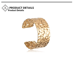 Detailed macro view of the gold hammered texture on the wide open cuff bracelet