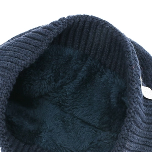 Detail of navy blue knit beanie showing thick fleece lining and ribbed texture