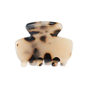 Detailed close-up of a mini beige and brown tortoiseshell acetate claw hair clip on white background