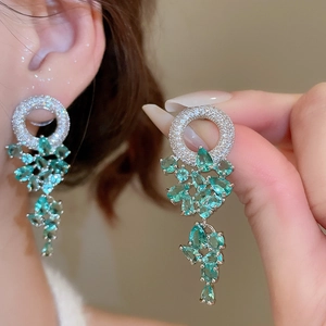 Détail de boucles d'oreilles en argent avec zircons brillants et gouttes vert menthe