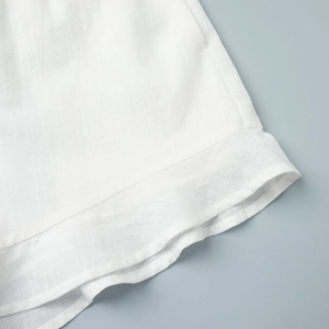 Détail du tissu en coton et lin blanc avec ourlet à volants et coutures de précision