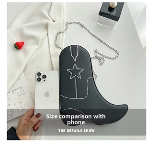 Black cowboy boot crossbody bag with white contrast stitching and silver metal chain