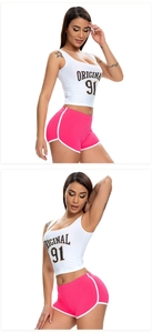 Detail of high-waisted yoga shorts in rose pink paired with a white sports tank top