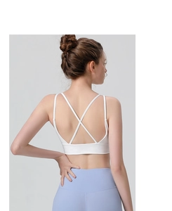 Close-up of white sports bra with cross-back thin straps and wide support band