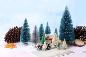 Detailed close-up of mini sisal Christmas trees with wood bases and snow effect