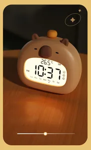 Macro shot of Capybara smart clock screen showing time and temperature with warm night light