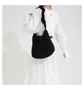Detail of black pleated cloud tote bag with 3D popcorn texture and matching shoulder strap